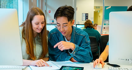 Two students in a computer lab.
