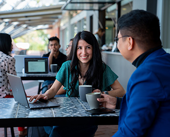 Students chatting and looking at laptop