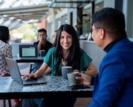 Students chatting and looking at laptop