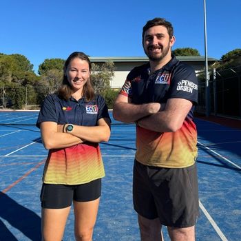 Royan Norman & Jake Whan standing on the ECU courts, wearing their sports uniforms and smiling.