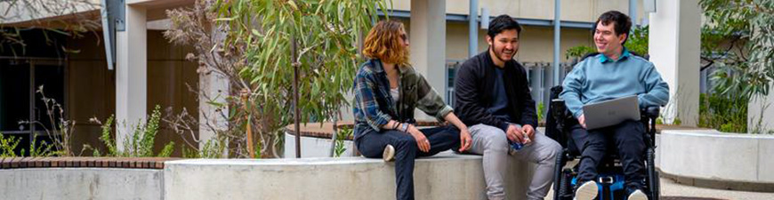students sitting outside campus building