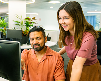 A student getting feedback from a mentor at their workstation.